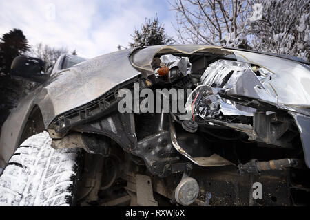 Broken auto luce incidente. Chiusura del faro anteriore danneggiato in una parte anteriore della vettura, l'inverno. Foto Stock