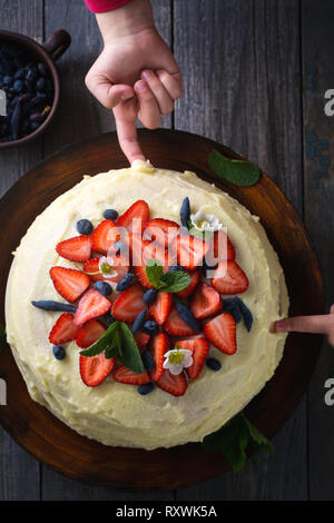 Kids provare la torta con le fragole Foto Stock