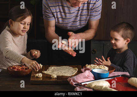 I bambini aiutano i papà cook Foto Stock