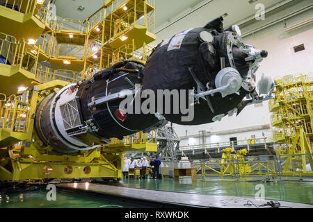 Il russo Soyuz MS-12 lander è abbassato in posizione per incapsulamento nel naso la carenatura del razzo vettore di integrazione la costruzione presso il cosmodromo di Baikonur il 6 marzo 2019 di Baikonur in Kazakhstan. La spedizione 59 equipaggio: Nick aia e Christina Koch della NASA e Alexey Ovchinin di Roscosmos lancerà 14 marzo per un periodo di sei-e-un-metà mese missione sulla Stazione spaziale internazionale. Foto Stock