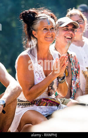 I frequentatori del festival frequentare un outdoor drumming workshop nei boschi a nel selvaggio festival, Kent, Regno Unito Foto Stock