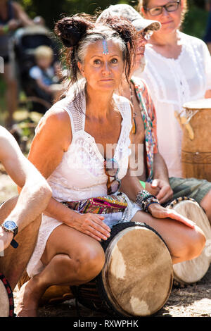 I frequentatori del festival frequentare un outdoor drumming workshop nei boschi a nel selvaggio festival, Kent, Regno Unito Foto Stock