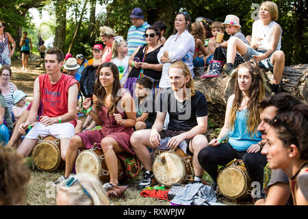 I frequentatori del festival frequentare un outdoor drumming workshop nei boschi a nel selvaggio festival, Kent, Regno Unito Foto Stock