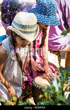 I frequentatori del festival frequentare un outdoor drumming workshop nei boschi a nel selvaggio festival, Kent, Regno Unito Foto Stock