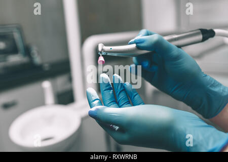 Dettaglio della mano che tiene gli strumenti dentali in dental clinic. Concetto di dentista. Foto Stock