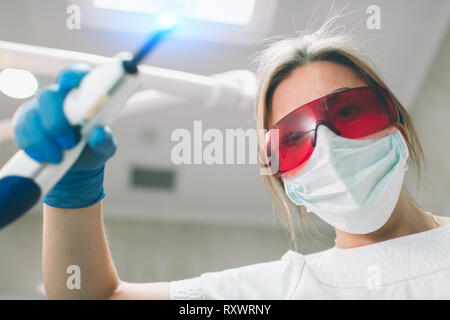 Ritratto di donna dentista . Ella esaminando una denti del paziente in . Foto Stock