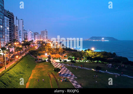 Vista aerea di Maria Reiche Park al tramonto con scenic seascape e chorrilos cross in background. I turisti, le famiglie e i bambini a giocare e visitatore occasionale Foto Stock