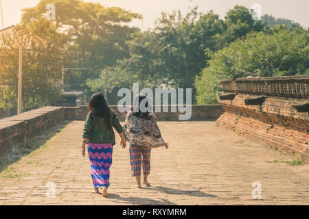 Backview femminile di turisti alla antica Pa Hto Taw Gyi Pagoda rovine a Mingun città vicino a Mandalay, Myanmar. Foto Stock