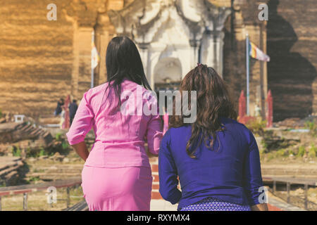 Backview femminile di turisti alla antica Pa Hto Taw Gyi Pagoda rovine a Mingun città vicino a Mandalay, Myanmar. Foto Stock