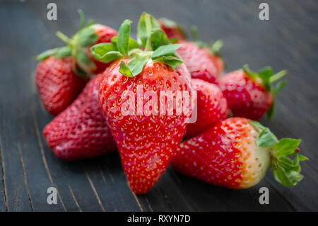 Belle fragole mature per la vendita su un vassoio in contenitori di legno. senza materia plastica Foto Stock