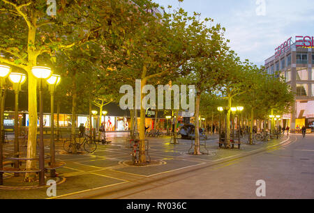 Francoforte, Germania - 3 Settembre 2018: Biciclette parcheggiate da alberi di downtown alley, street lanterne incandescente in sera Foto Stock