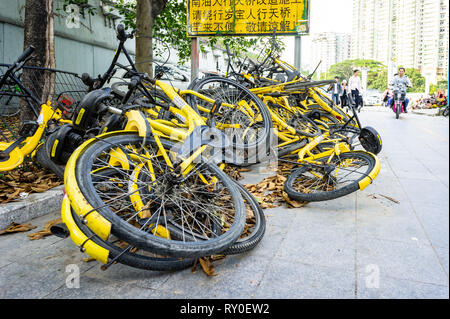 Cumulo di Ofo shared biciclette oggetto di dumping su strada di Shenzhen, Cina Foto Stock