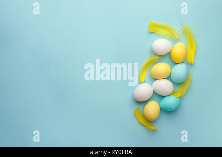 Uova pasquali dipinte in colori pastello su sfondo blu. Pasqua la minima nozione, spazio di copia Foto Stock
