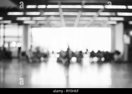 Blur sullo sfondo : i passeggeri in attesa del volo al terminal aeroportuale la sfocatura dello sfondo bokeh di fondo con luce. Foto Stock