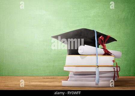 Cappello di laurea, diploma di scorrimento e i libri sul tavolo di legno con lo sfondo della lavagna Foto Stock