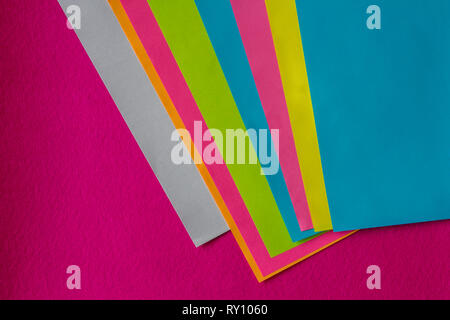 Texture di alcuni fogli di carta colorata e sfondo fucsia Foto Stock