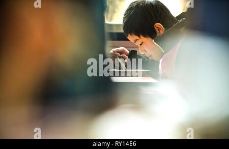 (190311) -- SHENYANG, 11 marzo 2019 (Xinhua) -- Zhou Xiaoyu ha il suo pasto durante l'ora di pranzo a Shenyang Sport University, a Shenyang del nord-est della Cina di Provincia di Liaoning, il 24 gennaio, 2019. Ci sono una trentina di bambini da 8 a 16 anni studiando snowboard halfpipe a Shenyang Sport University. Alcuni di loro vogliono diventare atleti professionisti, e alcuni di loro vogliono solo per avere un assaggio di questo sport. Come Pechino 2022 Giochi invernali si avvicinò di più e più persone in Cina, compresi i giovani studenti, ha cominciato a imparare e a partecipare nel ghiaccio e sport della neve. (Xinhua/Xia Yifang) Foto Stock