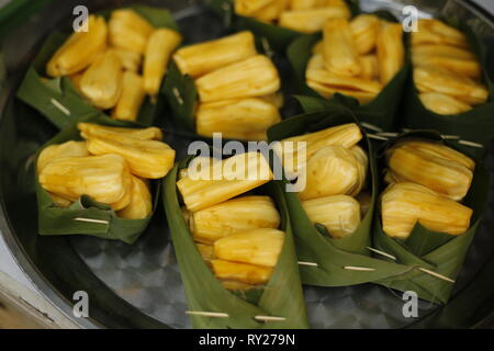 Freschi sbucciati jackfruits in banana leaf bocce sul mercato locale. Tradizionale Tailandese delizia fresca. Foto Stock