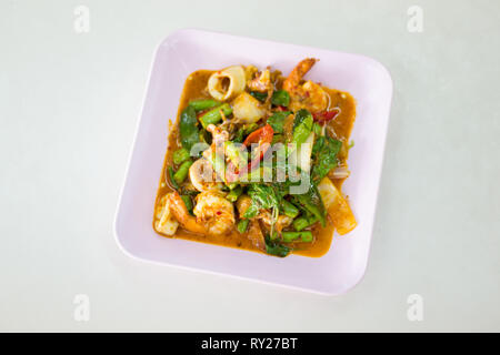 Mix di gamberi e pesce calamari fritti con cipolla, peperoncino e verde lungo in red hot salsa al curry. Tradizionale a sud-est di cucina asiatica. Foto Stock