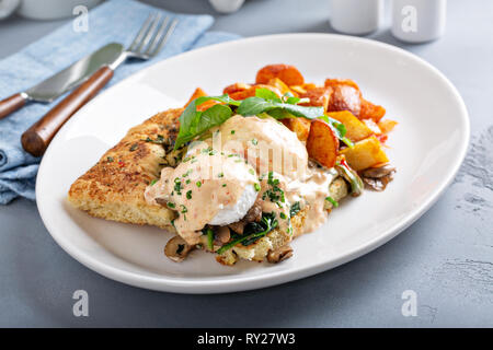 Uova Benedict con focaccia e patate Foto Stock