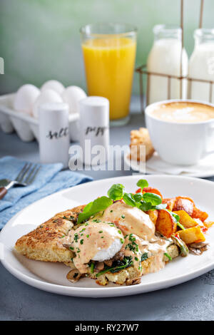Uova Benedict con focaccia e patate Foto Stock