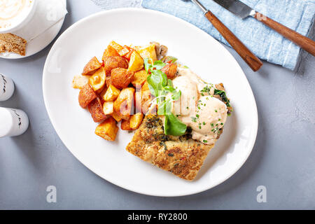 Uova Benedict con focaccia e patate Foto Stock