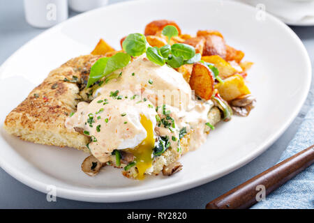 Uova Benedict con focaccia e patate Foto Stock