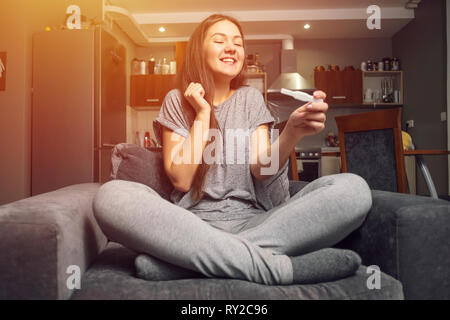 Sorpreso felice giovane donna e test di gravidanza Foto Stock