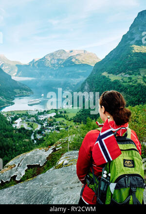 Uno zaino in spalla turistico guarda su Geirangerfjord dal punto di vista Flydalsjuvet Geiranger, Sunnmøre, Møre og Romsdal, Norvegia - turista norvegese del turismo Foto Stock