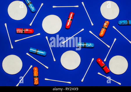 Concetto del periodo mestruale. Le donne a salvaguardia dell'igiene. Fiori multicolori con tamponi colorati petali su uno sfondo blu Foto Stock