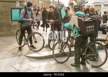 Gruppo di Deliveroo e Uber mangia i piloti in appoggio in Newcastle City Centre, a nord-est dell' Inghilterra, Regno Unito. Foto Stock