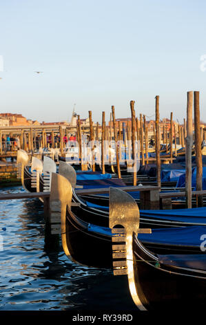 Sulla foto ci sono parcheggiate sul canale d'acqua le gondole, vista verticale durante il suset. Foto Stock