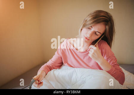 Assonnato giovane donna di svegliarvi con allarme. Ella overslept al lavoro Foto Stock