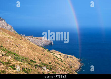 Selvatica costa collinare di Creta isola dopo una pioggia con un arcobaleno Foto Stock