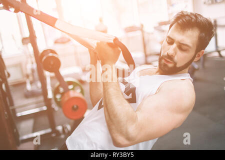 Muscolare uomo barbuto durante gli allenamenti in palestra. Foto Stock