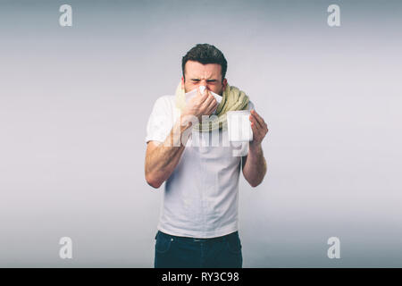 Studio immagine da un giovane con fazzoletto. Ragazzo malato isolato ha naso che cola. uomo fa una cura per il raffreddore comune.Nerd è con gli occhiali Foto Stock