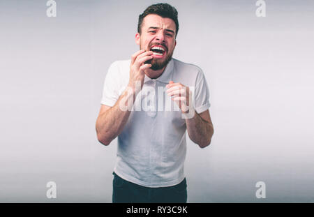 Problema di denti. L'uomo sensazione Dente dolore. Vista dettagliata del barbuto ragazzo soffre di un forte dolore a dente. Maschio attraente sensazione dolorosa mal di denti. Dental Foto Stock