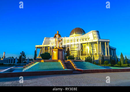 Mary Turkmenistan edificio della Biblioteca Nazionale con il Presidente Saparmurat Niyazov statua Holding Ruhnama prenota Foto Stock