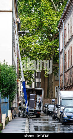 Strasburgo, Francia - Sep 12, 2017: giovane lavoratore di sesso maschile in attesa per l'ascensore idraulico braccio per erogare un altro pacchetto durante il trasferimento iniziale Foto Stock