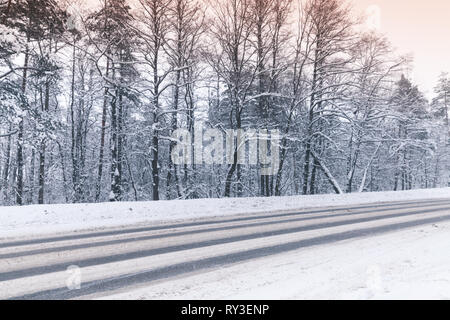 Paesaggio invernale con un vuoto di autostrada passando attraverso la foresta Foto Stock
