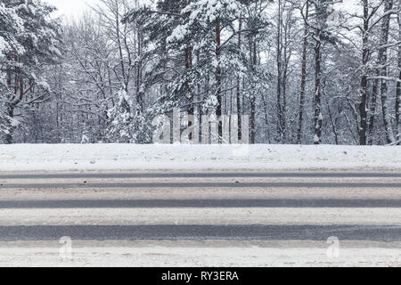 Paesaggio con un vuoto di inverno autostrada passando attraverso la foresta Foto Stock
