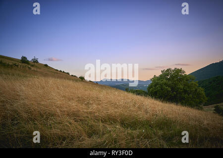 Vista panoramica al tramonto del paese sul lato della zona appenninica in Umbria (Italia). Foto Stock