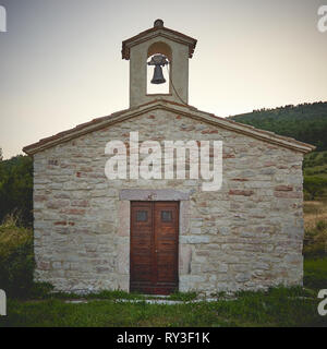 Una tipica piccola rinnovato chiesa di pietra in un villaggio rurale sulle montagne del centro Italia. Formato quadrato. Foto Stock