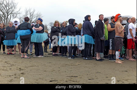 I partecipanti al Polar Plunge 2019 aspettano in fila per fare un tuffo nelle acque ghiacciate del lago Erie al largo di Edgewater Park a Cleveland, Ohio, Stati Uniti. Foto Stock