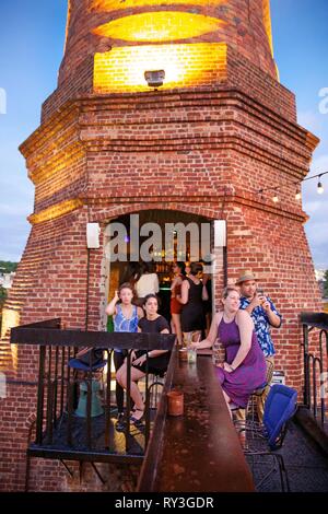 Cuba, La Habana, Vedado, turisti nella barra impostata nella ciminiera in mattoni di el Cocinero ristorante nel centro multiculturale la Fabrica de arte cubano Foto Stock