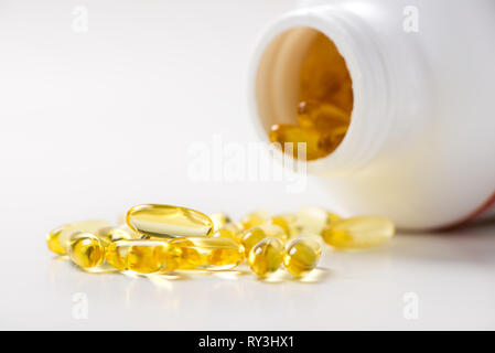 Omega 3 olio di pesce capsule fuoriuscita di una bottiglia Foto Stock