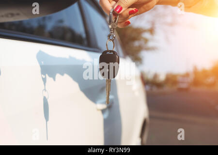 Giovane donna tenendo in mano le chiavi dell'auto. Foto Stock