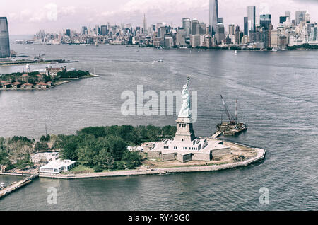 Vista elicottero della Statua della Libertà con la parte inferiore di Manhattan in background. Foto Stock