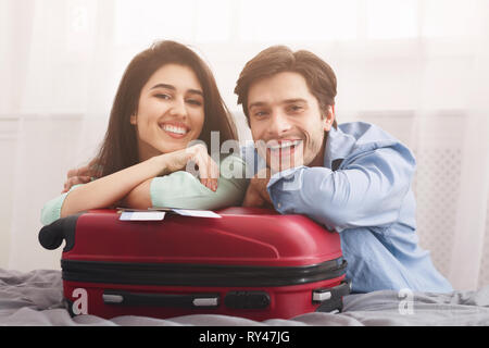 Amare giovane appoggiata sulla valigia, preparazione per le vacanze Foto Stock