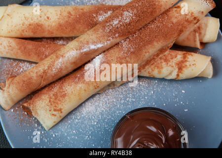 Frittelle con le bacche, marmellata, miele e cioccolato spolverati con zucchero a velo e cannella Foto Stock